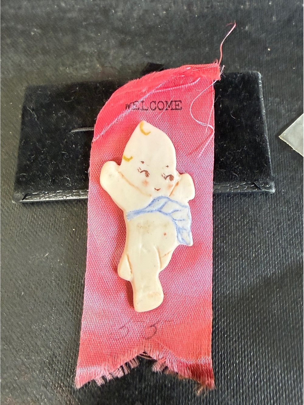 Vintage Ceramic Kewpie Doll Pin on Red Fabric Ribbon with 'WELCOME' Text